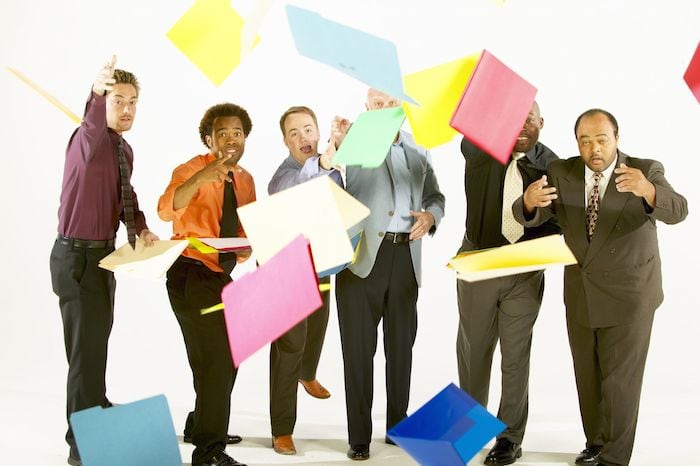 Business men throwing folders for no apparent reason
