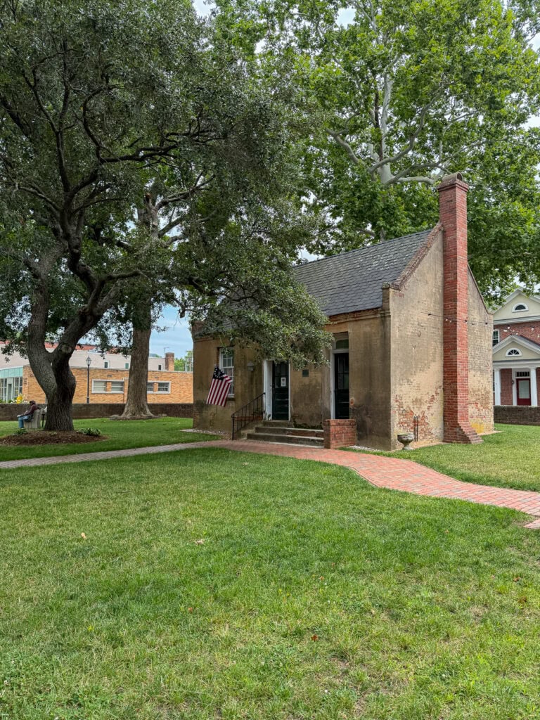 Charming historic house with brick chimney and lush green lawn in Gloucester, VA.